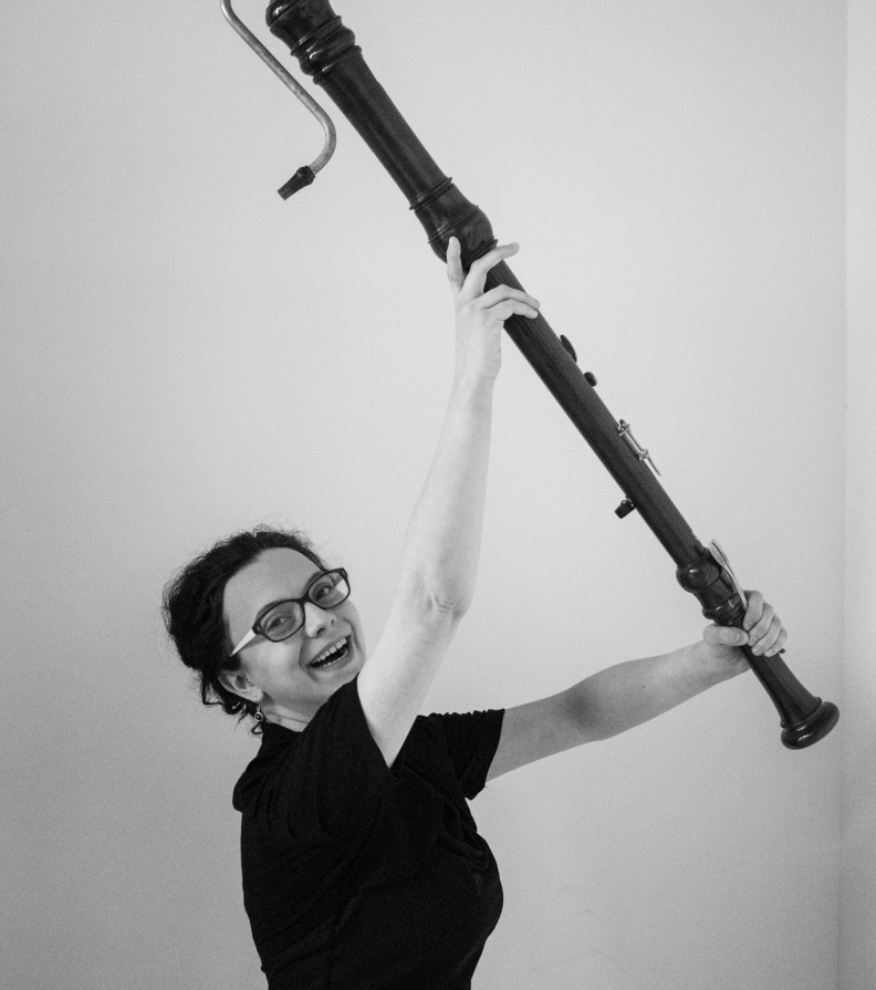 Kathrin Härtel hält mit beiden Armen eine Bassblockflöte schräg nach links oben. Foto: Kristin Härtel